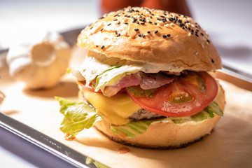 hamburger with beef patty tomato bacon cheese with blurry background