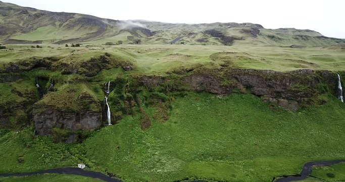 4K Aerial Drone footage from the sky of Iceland waterfall valley in the southern region. Beautiful green Icelandic landscape