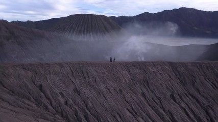 AERIAL: A hikers walks at the edge of Bromo volcano in Java island, Indonesia