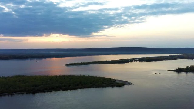 Aerial drone landskape with sunset over Volga river, islands covered with green forest and zhiguli hills at background in Samara, Russia