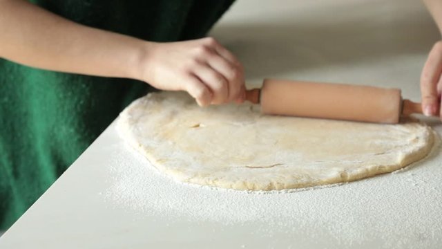 Crop woman rolling soft dough