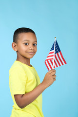 Cute boy with american flag on blue background