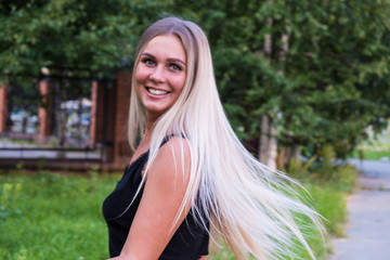 Naklejka premium Portrait of a beautiful young woman with long shiny blond hair looking at the camera. Hair care concept.