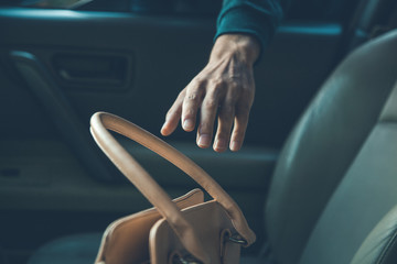 a thief steals bag in car