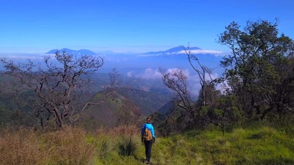 Woman rising hands on the mountain area of Java island, Indonesia, drone shot