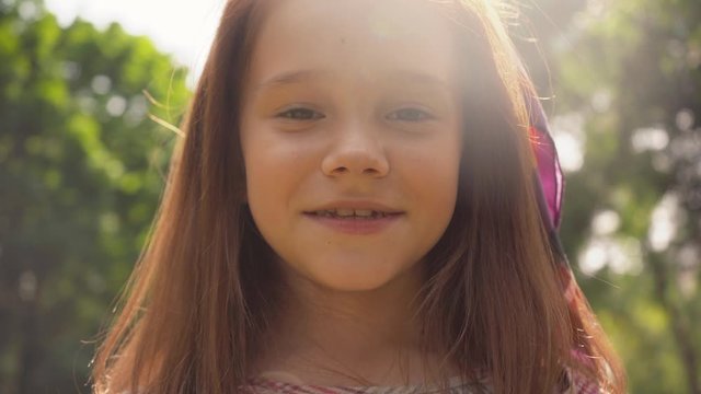 cute smiling child in sunlight in green park