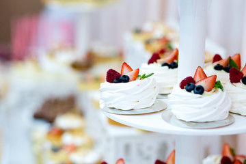 Delicious sweet buffet with macaron cupcakes, sweet candy bar with cupcakes and meringues and other desserts