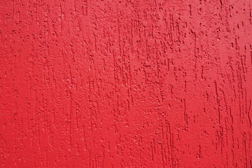Abstract background and texture of a plastered wall in bright red with bark beetle texture....