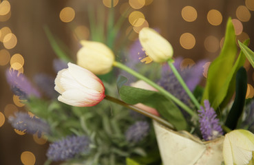 tulips and lavender bouquet on golden light background of vintage confetti in soft blur. Pattern, background, texture, poster, postcard. Holidays, Christmas and Valentine's Day