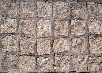 The pavement is paved with old medieval cobblestones in ordered rows.