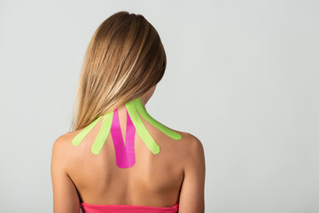 Therapeutic tape medicine on neck of a young woman - obrazy, fototapety, plakaty