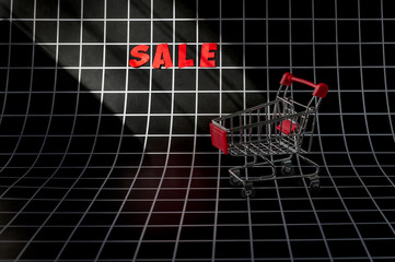 Shopping cart and Sale text on checkered background with copy space. Black friday sale concept.