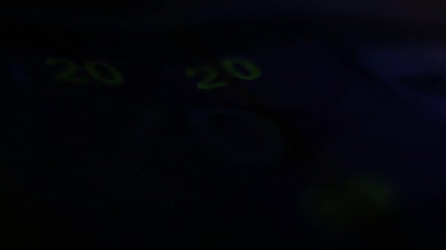 Close Up Of 20 Litas Banknote And Ultraviolet UV Light Counterfeit Bill Detector.