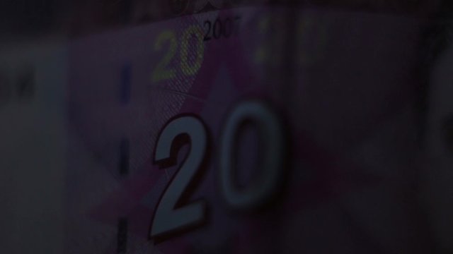 Close Up Of 20 Litas Banknote And Ultraviolet UV Light Counterfeit Bill Detector.