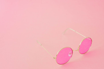 Round hipster sunglasses with pink lenses and golden frame. Fashion accessory for women