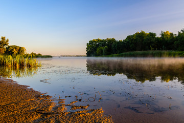 Fog above the water surface. Sunrise at river