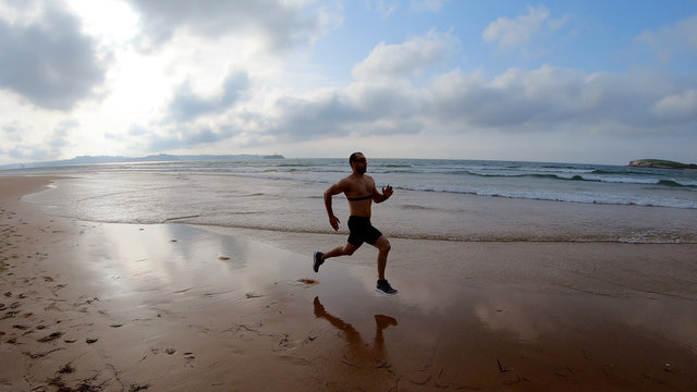 Athlete silhouette of runner running on beach