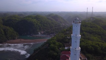 Aerial: People admiring the landscape from Lighthouse Pantai Pandansari in Bantul region at Java island , Indonesia