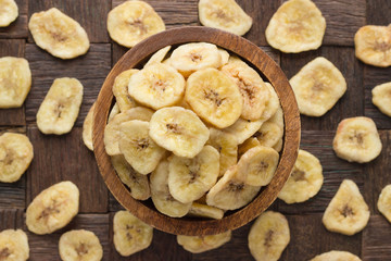 dried fruit, banana chips in wooden bowl, top view.