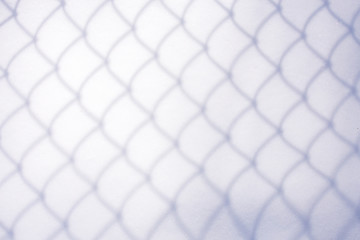 shadow of chain link fence in fresh snow