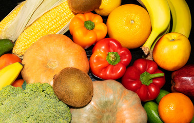 Assortment of fresh fruits and vegetables such as pumpkin, tomato, capsicum, broccoli, carrot, cucumber, corn, orange, lemon, banana, apple. 