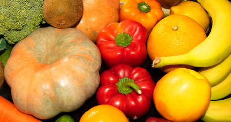 Assortment of fresh fruits and vegetables such as pumpkin, capsicum, broccoli, carrot, orange, lemon, banana, apple. 