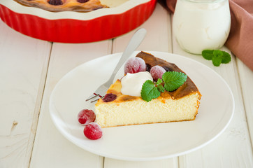Diet healthy cottage cheese cake with cherries and sour cream on a white wooden background.
