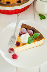 Diet healthy cottage cheese cake with cherries and sour cream on a white wooden background.