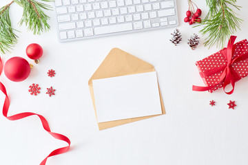Mockup white greeting card and envelope, pine branches and keyboard with christmas decorations on a white background