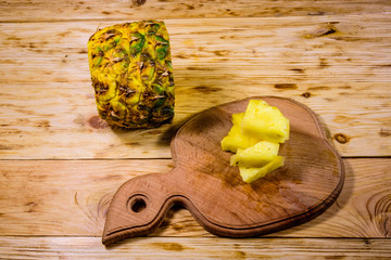Cutting board with sliced pineapple on wooden table