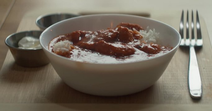 Closeup shot of butter chicken on the table. Cinematic 4K footage.