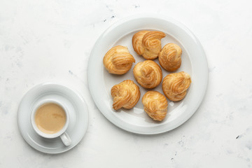 Homemade profiteroles with cream and coffee. Close-up.