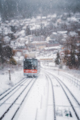 Defocused window view of funicular traveling through snowy scenery