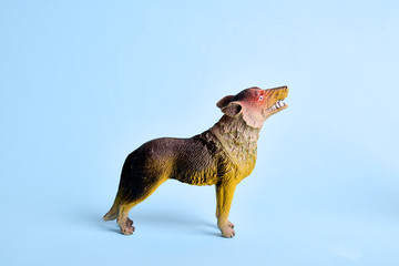 Plastic wolf toy isolated in front of blue background. Copy space