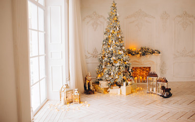 classical interior of a white room with a decorated fireplace, luxury Christmas tree, garlands, candles, lanterns, gifts. day. pink sofa pastel colors