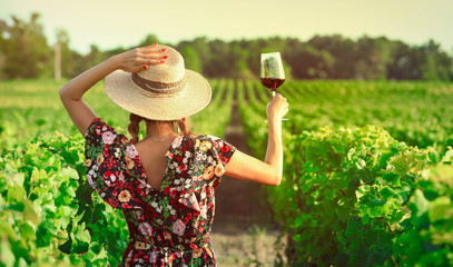 Asian woman drinking red wine at vineyard during her vacation