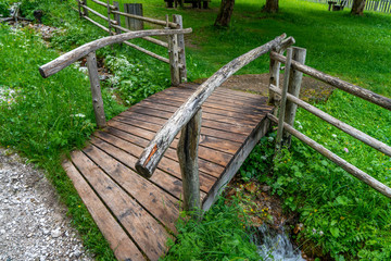Eine hölzerne Brücke über einem kleinen Bachlauf in einem Park