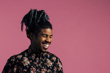 Portrait of a laughing man with cool hair and eyes closed