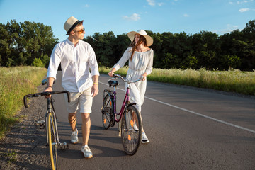 Couple of bicycle fellow travelers chatting on a sunny countryside road