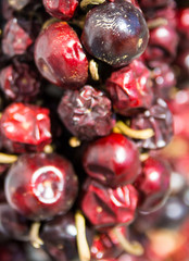 Dried round red chilli on a market stall with out of focus areas on the right.