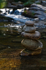 Fototapeta na wymiar Zen rocks or pebble stack on river waters. Peaceful and spiritual theme