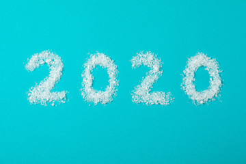 2020 laid out of snow on turquoise background, copy space