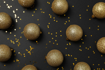 Christmas balls and glitter on black background. Happy new year
