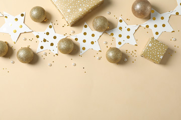Christmas balls, stars and presents on color background, space for text