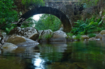 Antique arched stone bridge over Gralheira river in Carvalhais, Sao Pedro do Sul, Portugal