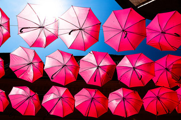 Pinke Regenschirme in einer Straße in Frankreich