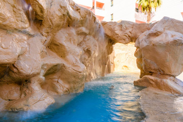 Small waterfall with turquoise water in the hotel pool