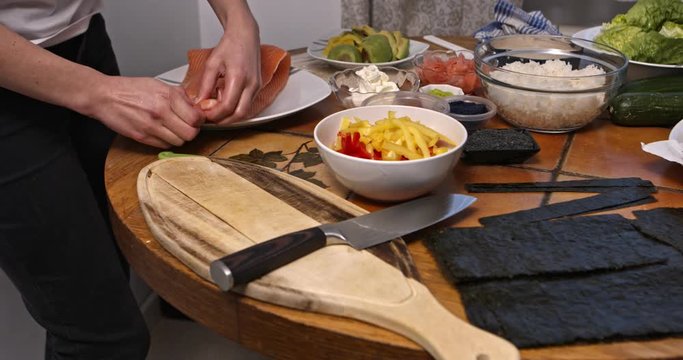 Preparing raw salmon for cutting on bard as ingredient for sushi. Cooking meal.