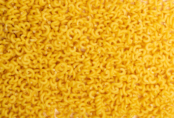 Raw yellow cavatappi pasta texture background top view