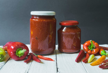 Fresh Ajvar made of tomatoes and paprika on the rustic wooden table.